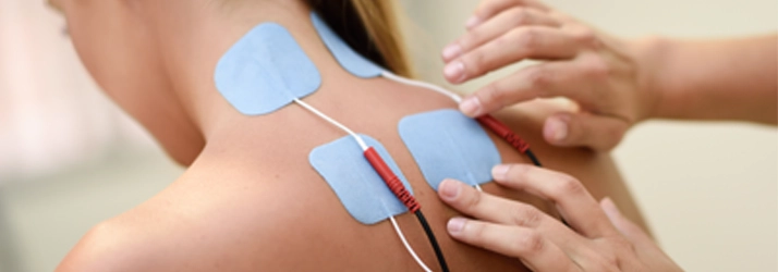 Chiropractic Davidson NC Electric Muscle Stimulation A person with Electric Muscle Stimulation patches on their upper back.