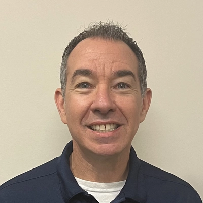 Chiropractor Seth Moliver smiling in a blue polo.